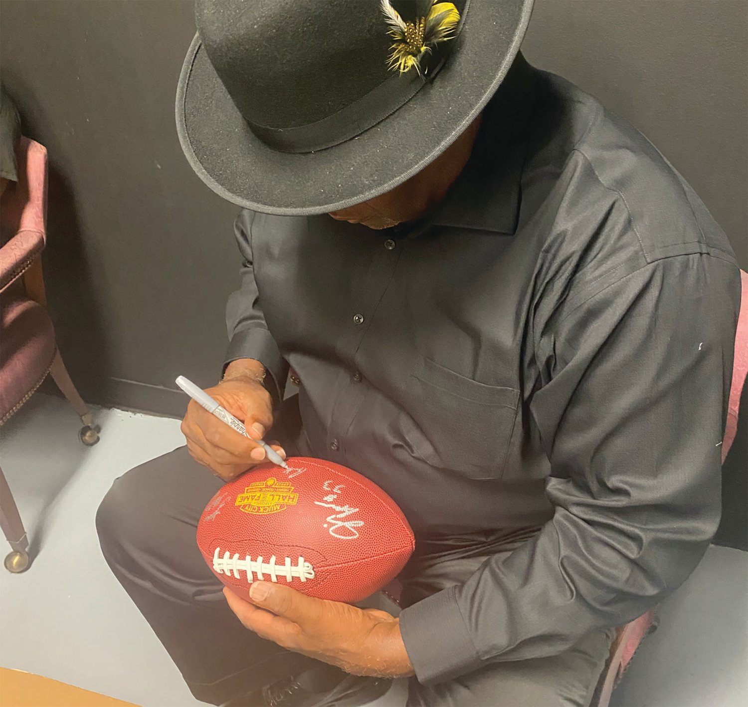 Hall of Famer Rickey Jackson signs a commemorative football.